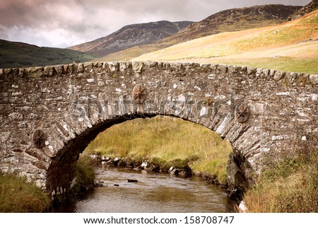 Ancient stone bridge over river,Highlands, Scotland, UK. Retro style processing.