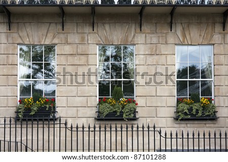 Georgian window triptych. Detail of windows with windowboxes and wrought iron railings on facade of Georgian building.