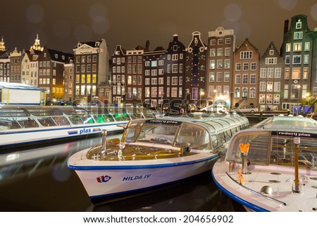 AMSTERDAM, NETHERLANDS - JULY 08: Amsterdam canal with traditioal houses and tour boats. Seeing Amsterdam from the water is very popular with tourists. July 5 2014, Amsterdam, Netherlands