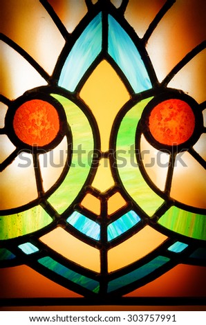 Detail of an old, 1920s style Art Deco window. Colourful stained glass texture with vignette.