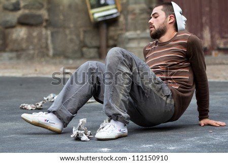 AURILLAC, FRANCE - AUGUST 24:a masked man sits down in the street as part of the Aurillac International Street Theater Festival,show by the Company Idem,on august 24, 2012, in Aurillac,France.