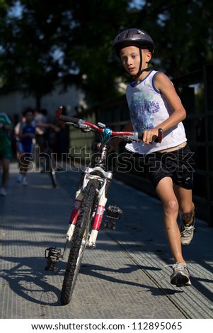 AUCH, FRANCE - SEPTEMBER 8: an unidentified young  runner in the transition area, Auch Triathlon for children, on September 8, 2012 in Auch, France.
