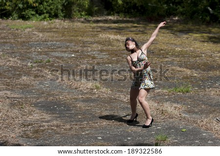 Sensual contemporary dancer on a waste ground. It is a french woman. She wears a short dress and  high heels.
