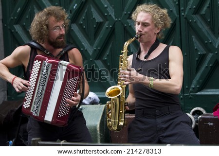 AURILLAC, FRANCE- AUGUST 20: two musicians,an accordionist and a saxophonist, play in the street as part of the Aurillac International Street Theater Festival, on august 20, 2014, in Aurillac,France.