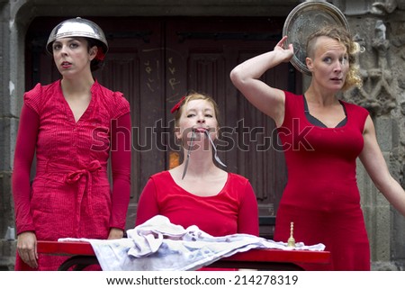 AURILLAC, FRANCE-AUGUST 20: three funny women in red clothes are ready for eating,  as part of the  Aurillac International Street Theater Festival, ,on august 20, 2014, in Aurillac,France.
