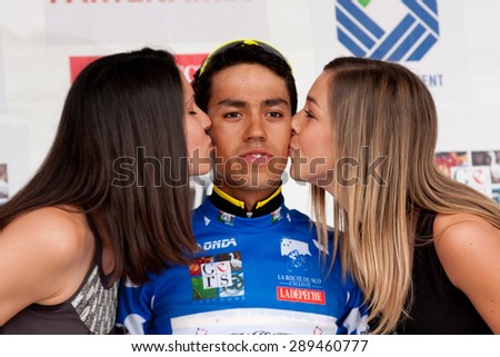 AUCH, FRANCE - JUNE 18:   The kiss of two cute hostesses to Daniel Martinez, young  Colombian racer, on the podium of the first stage of the Route du Sud, on June 18, 2015 in Auch, France.