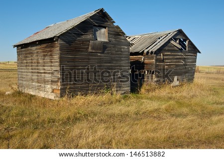 Two old abandoned wooden granaries in fall