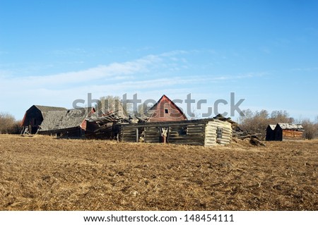 Old abandoned farm. Collapsed log house, old barns and old granaries.  Image taken in early spring