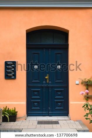 Old dark blue wooden front door with letterboxes and newspapers