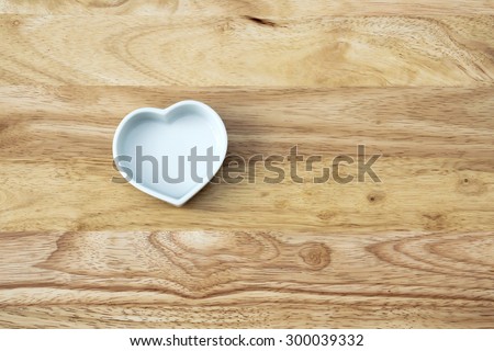 white heart shape cup of love on wood background