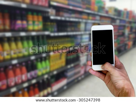 hand holding smart phone in supermarket