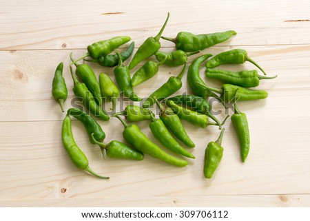 green chili spur pepper on wood table