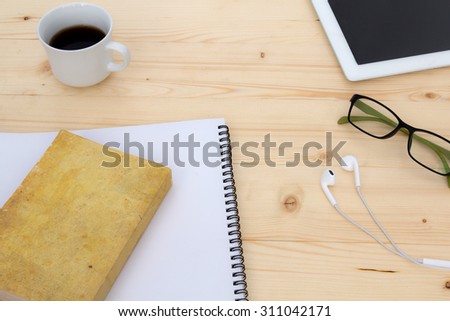 glasses ,book ,coffee and tablet with earphone on desktop