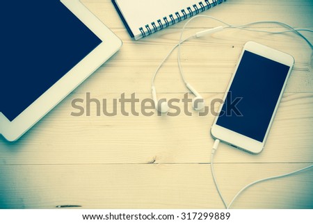 note book , mobile phone and notepad on desktop processed with vintage style