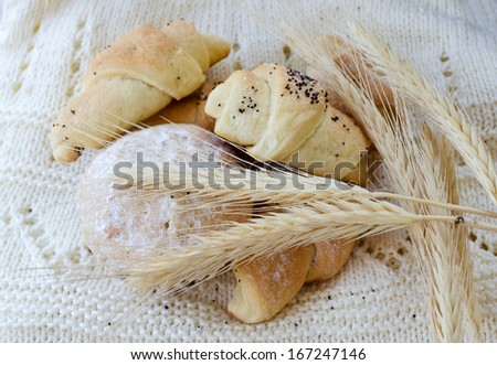 bagels and muffins on a knitted towel with wheat ears of wheat
