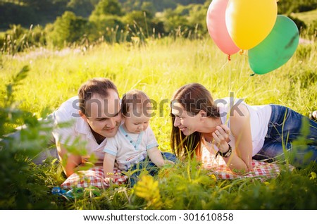 happy family with balloons celebrating birthday son in the park