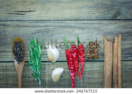 Colorful spices and herbs frame on a wooden background.