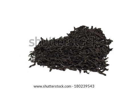Black leaf tea in the form of heart. Photo.