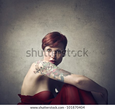 Beautiful elegant woman with a tattoo on her arm