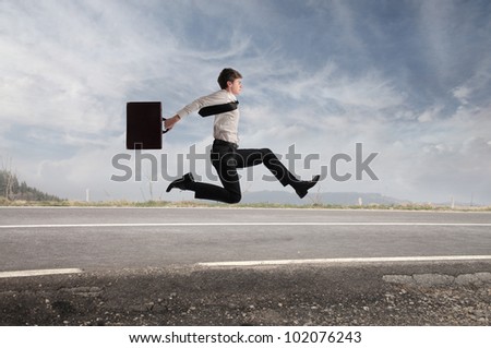 Young businessman running fast on a country road