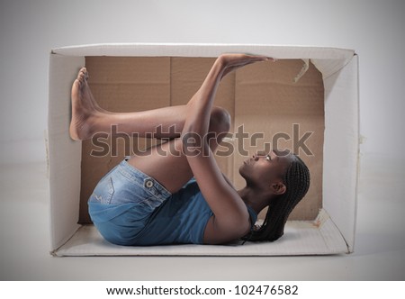 Young african woman stuck in a carton