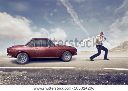 Businessman pulling an old car
