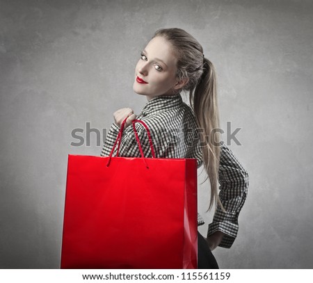 Beautiful blonde girl holding a red shopping bag