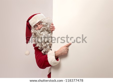 Santa Claus showing something on a white wall