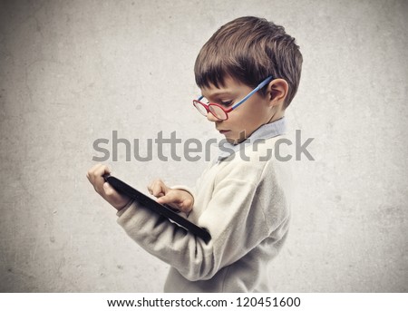 Child with glasses using a laptop computer