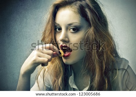 Seductive blonde girl eating a pretzel