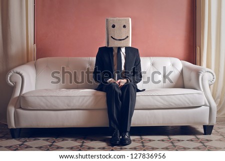 businessman sitting on sofa with head in box