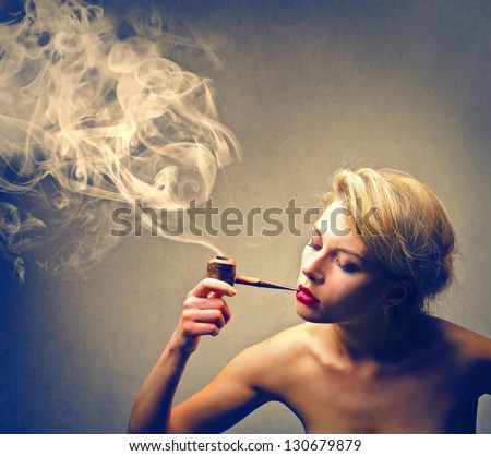 beautiful woman smokes a pipe