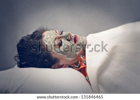 reclining woman with beauty mask on her face