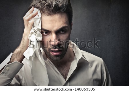 worried man wipes sweat on his face