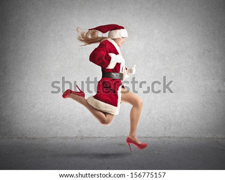 beautiful woman dressed as Santa runs fast