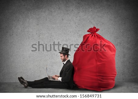 very rich businessman sitting on the floor working with laptop