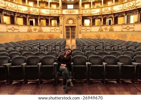 woman falling asleep in empty theater