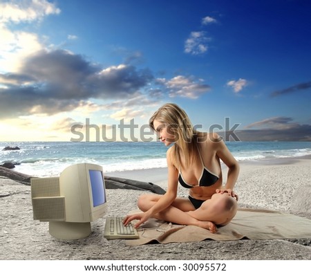 Pretty girl in bikini using old computer on the beach
