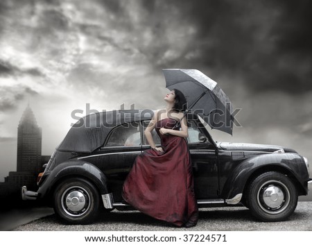 lady in purple dress and holding umbrella next to vintage luxury car