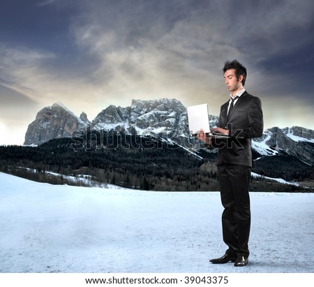 young businessman with laptop on a mountains landscape background