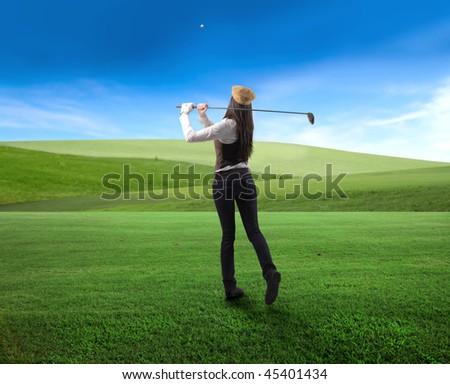 Woman playing golf on a green meadow