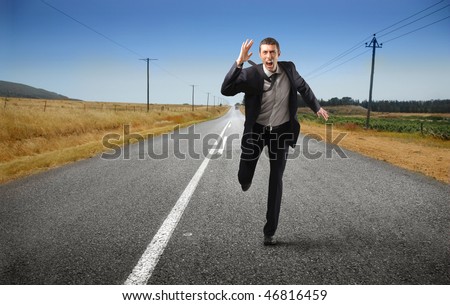 Portrait of a businessman running on a countryside road