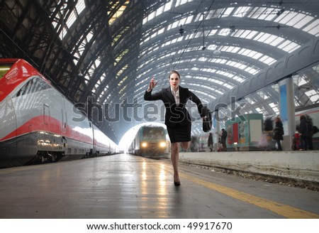 Businesswoman running on the platform of a train station