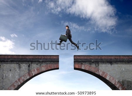 Businessman jumping a gap between two bridge parts