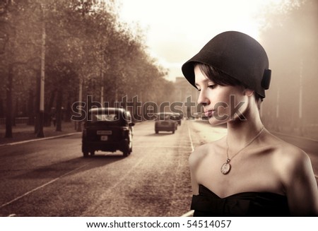 Beautiful woman in vintage clothes with street on the background