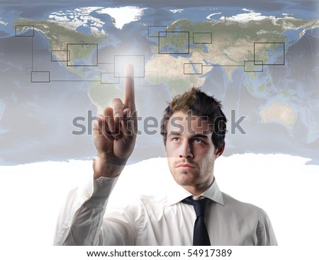 Businessman pressing the cell of a digital graphic with world map on the background