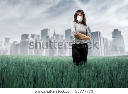 Sad woman wearing a surgical mask with polluted green meadow and city on the background