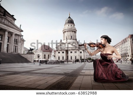 Beautiful woman playing the violin on a square in Berlin
