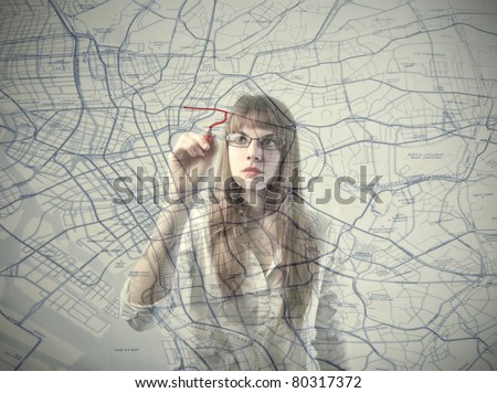 Businesswoman drawing a route on a city map