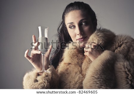 Beautiful rich woman holding a glass of champagne